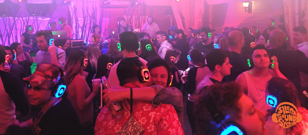 People dancing with Silent Sound System headphones on at a nonprofit partnerships event