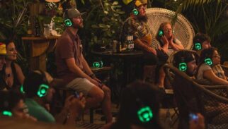 A group sits watching a performance while wearing Silent Sound System headphones